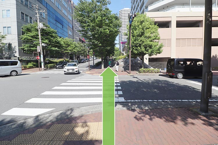 そのまま直進し、横断歩道を渡って引き続き道なりに進みます。